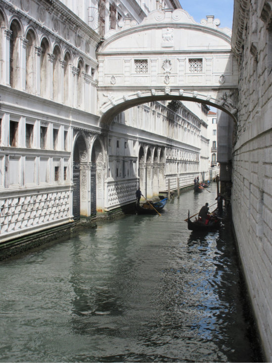 Bridge of Sighs over canal with gondolas in Venice